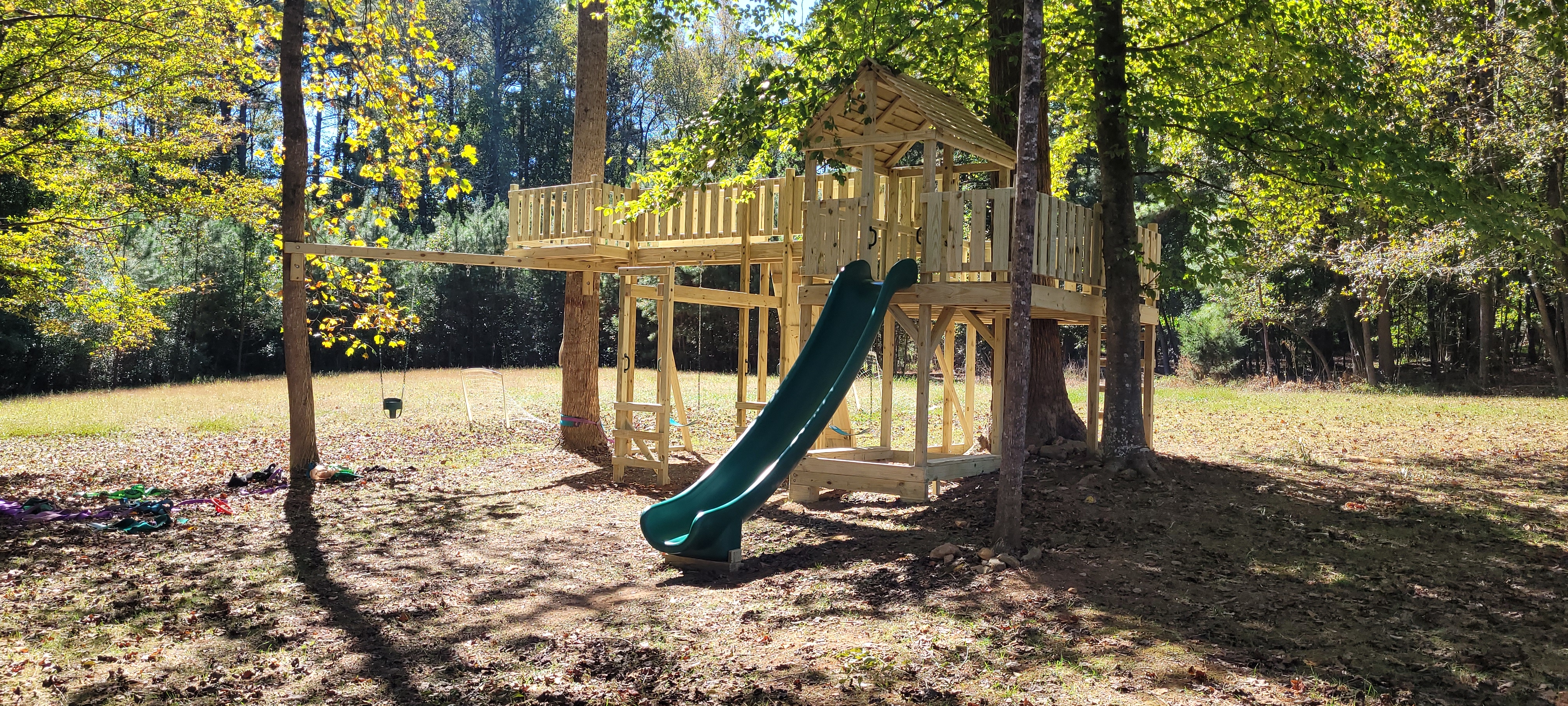 Beautiful custom wooden playset in a green backyard